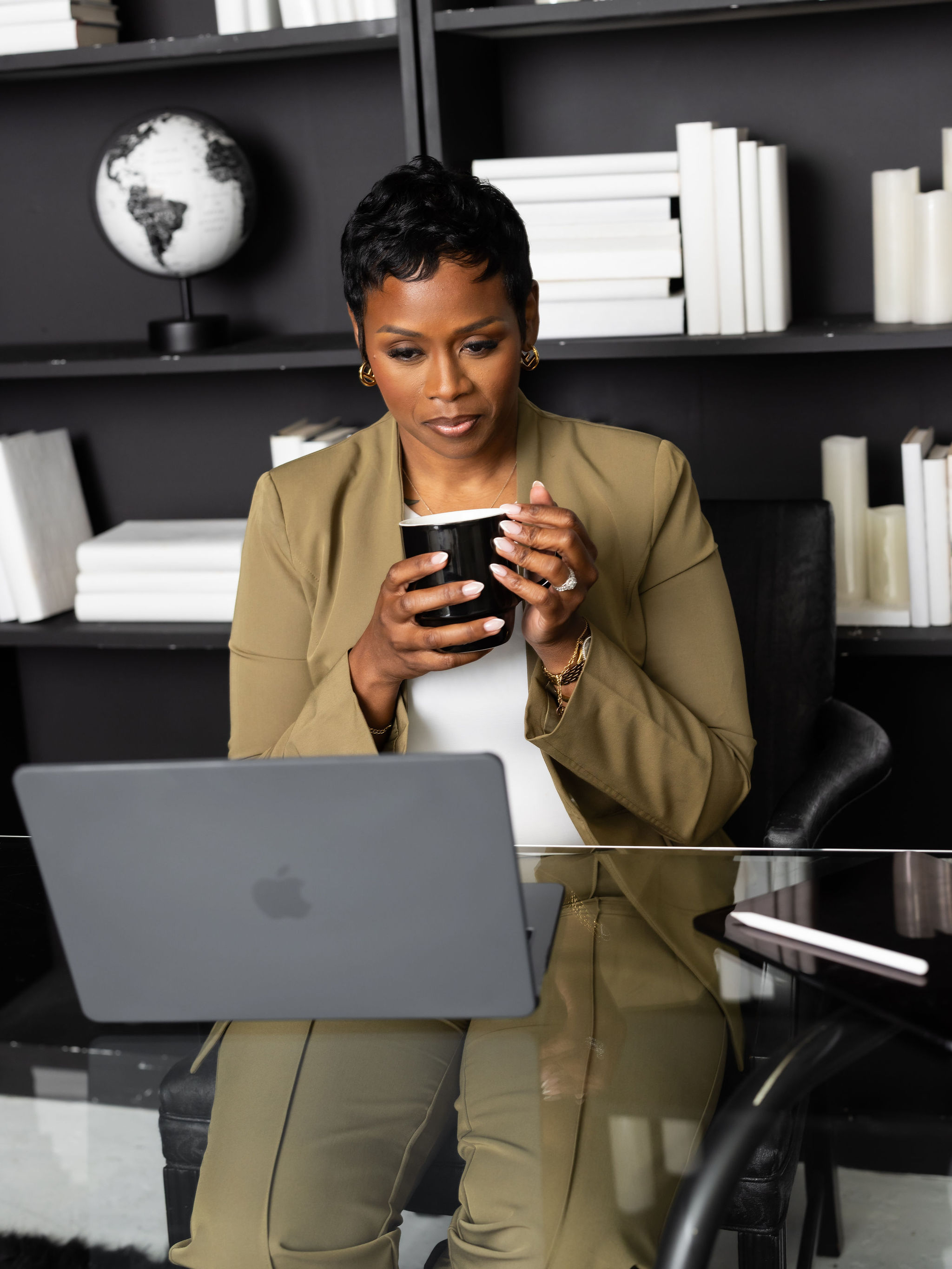 Autumn R. Russell holding a coffee cup beside her laptop