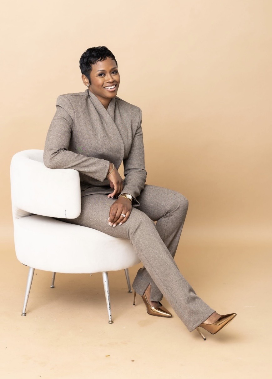 Autumn R. Russell seated in a taupe suit